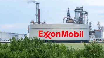 ExxonMobil refinery facility with large storage tank and industrial stacks in view